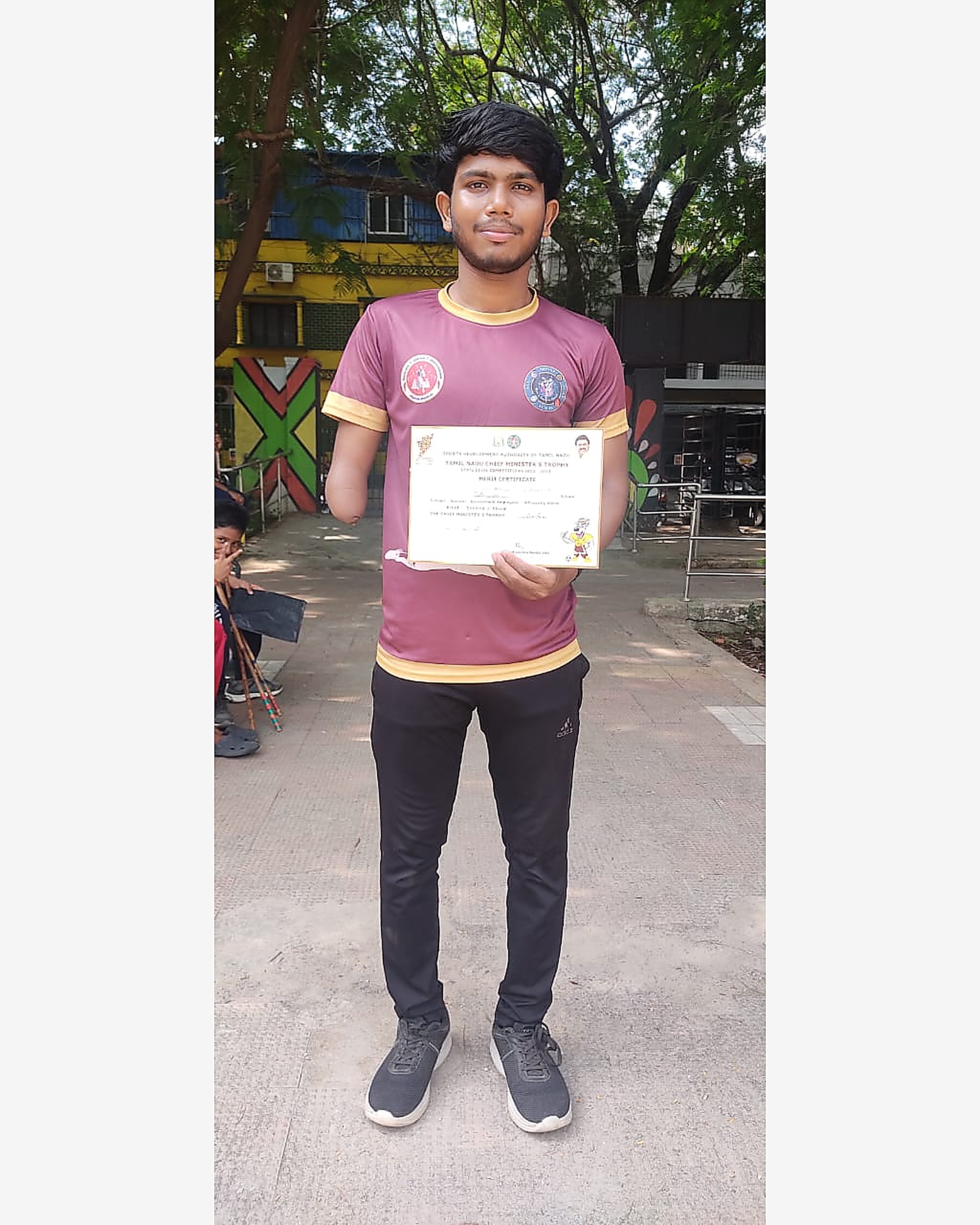 H3A student holding Tamil Nadu Chief Minister's Trophy merit certificate